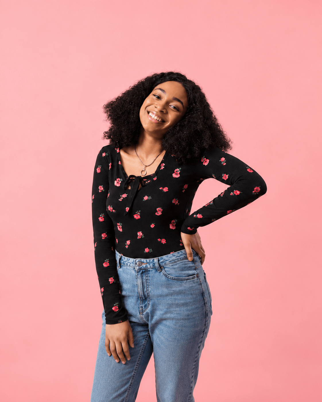 Woman smiling against a pink background
